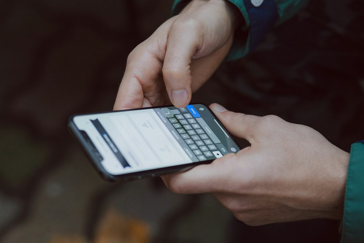 Hender som skriver en melding på en smarttelefon